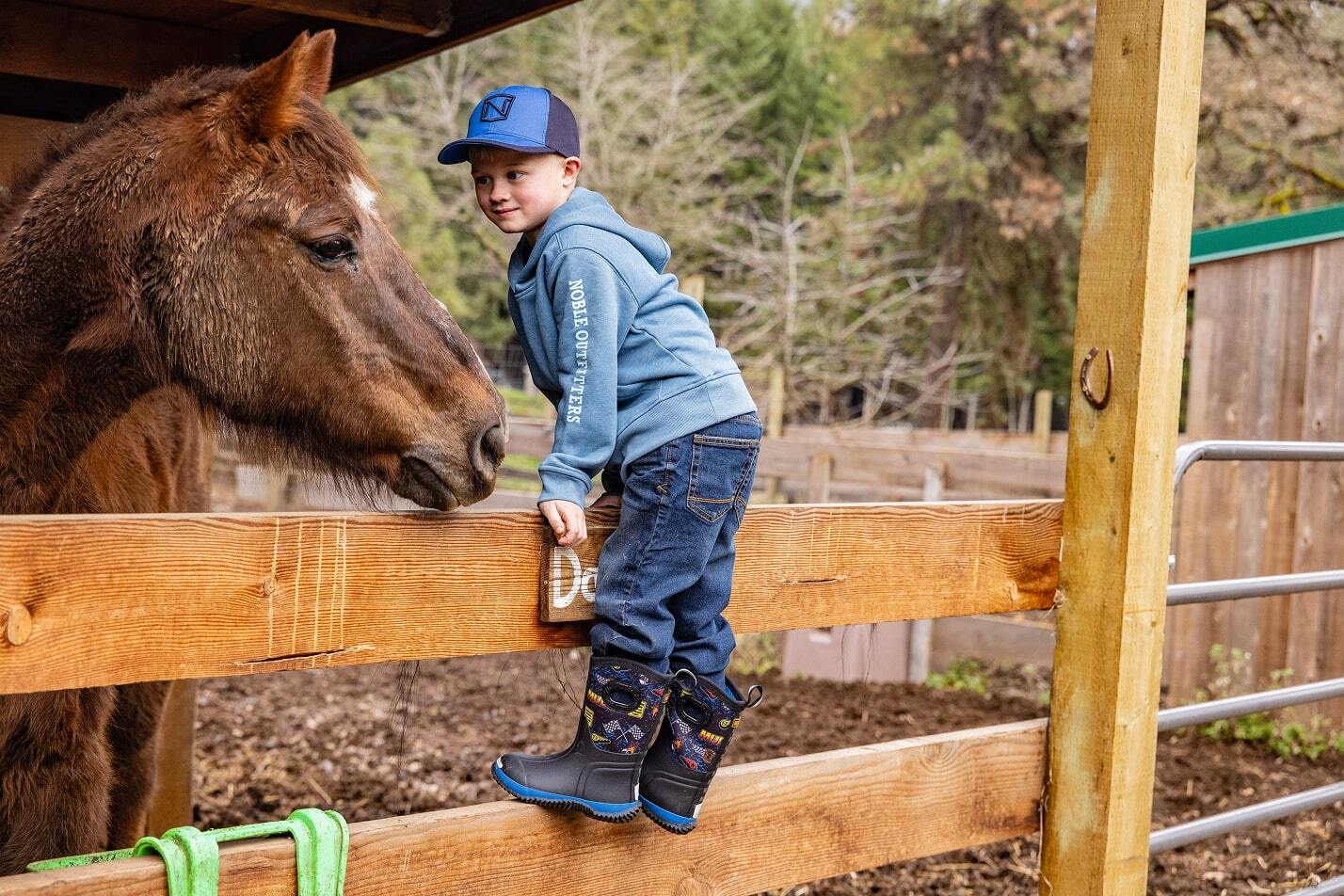 boy wearing muds with donkey